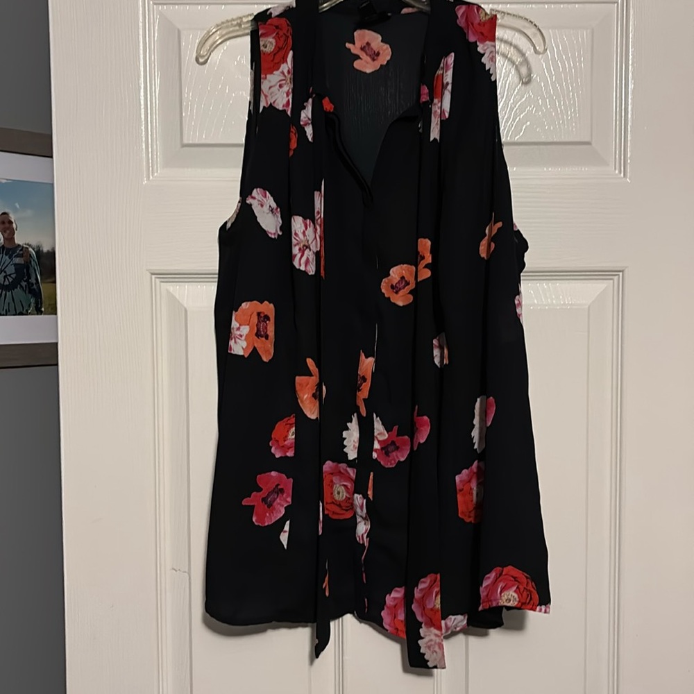 Previously loved sleeveless top black with colorful flowers.
